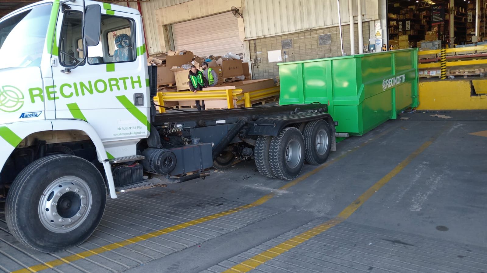 Camión RECINORTH con contenedor roll-off en planta industrial